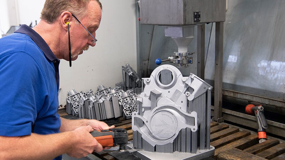 Das fertige Bauteil aus dem 3D-Drucker wird von der Bodenplatte gelöst. Fotos: GOM